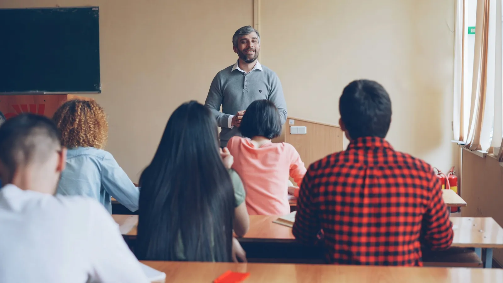 Profesor dando una clase a un grupo de alumnos adultos en una academia de idiomas