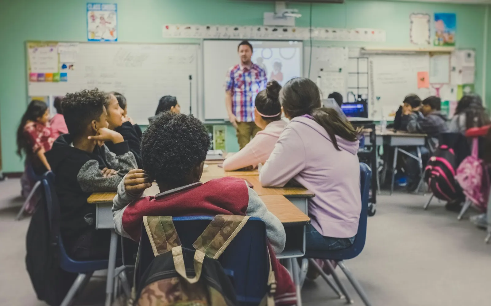 Profesor ayudando a un grupo de alumnos en un centro de refuerzo escolar
