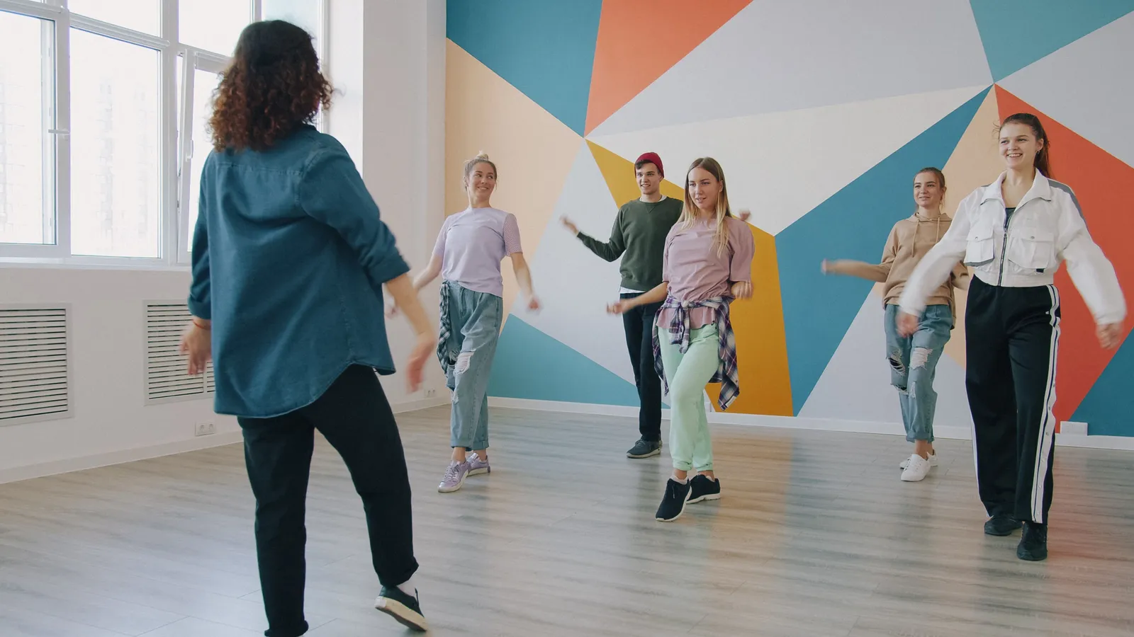 Grupo de alumnos bailando en una clase en una escuela de baile
