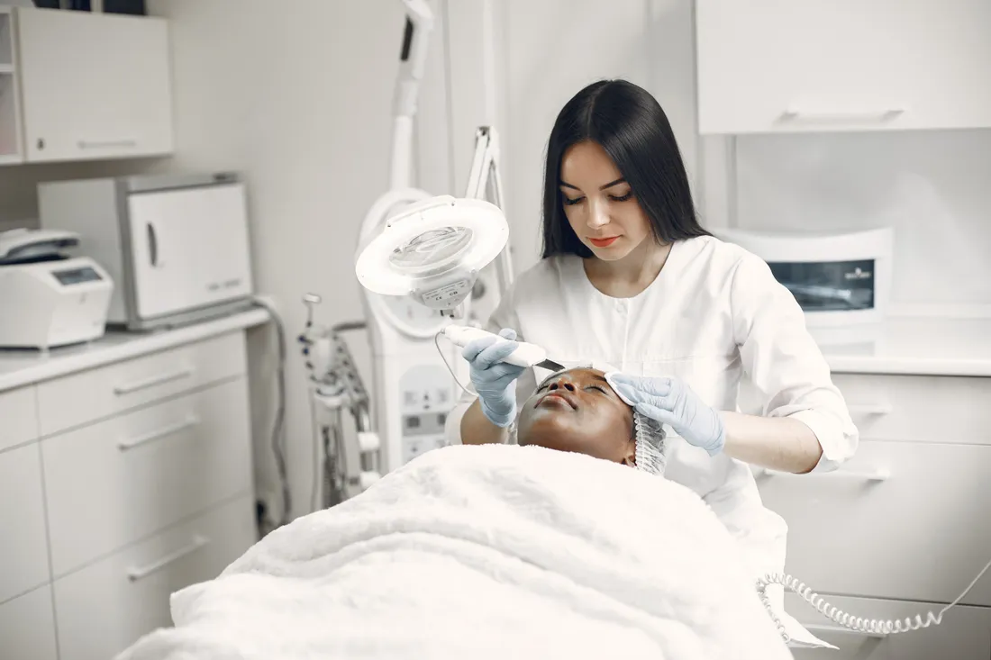 Profesional realizando un tratamiento facial con equipo especializado