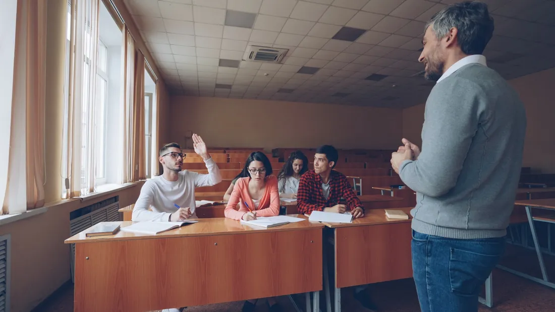 Profesor conversando con un pequeño grupo de alumnos en una academia de idiomas