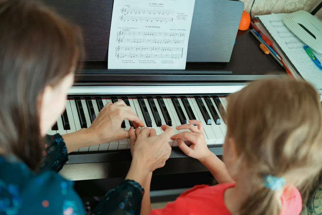 Profesor y alumna compartiendo una clase de piano