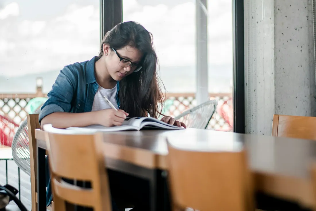 Opositora estudiando y tomando apuntes de su temario
